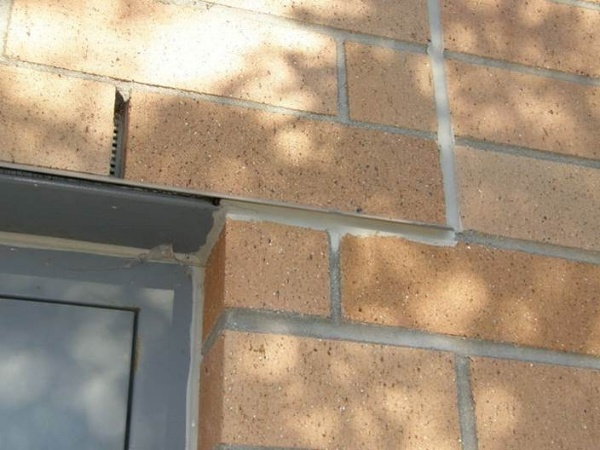 Figure7: Vertical movement joint properly located at the end of the beam bottom plate that supports the clay brick veneer at the door opening. Sealant properly installed under drip edge to prevent wind driven rain penetration.